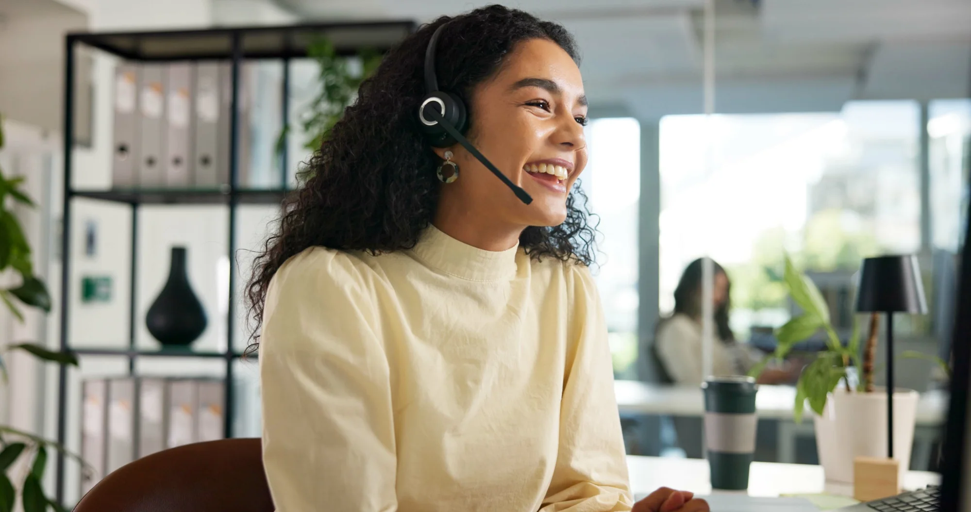 Professional front-desk coordinator speaking with a customer through a headset